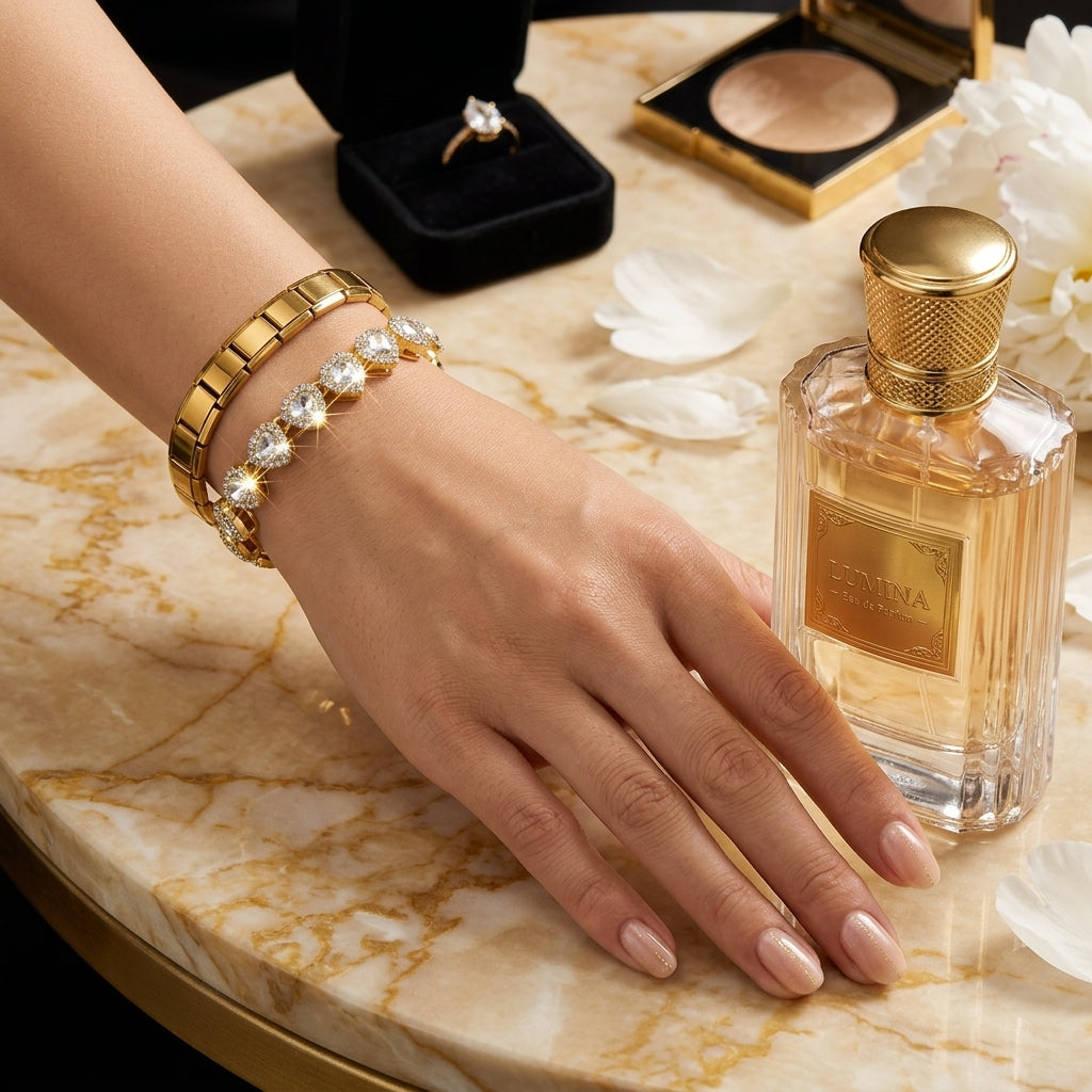 Hand with gold bracelet near a perfume bottle on a marble surface