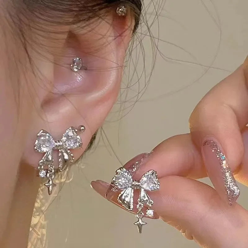 Elegant silver bow earrings with crystal accents and dangling star charms
