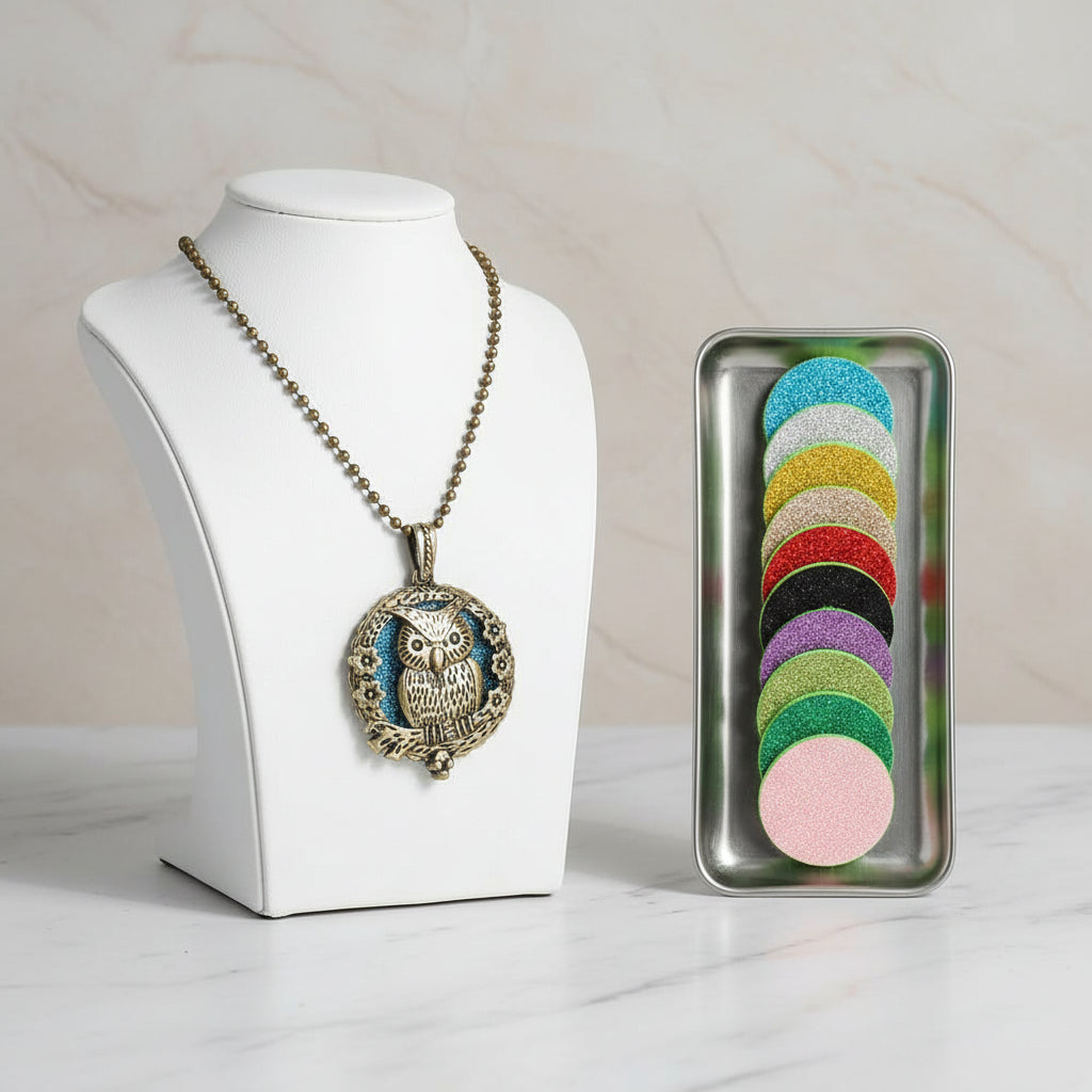Bronze owl-shaped necklace with a row of colorful round perfume pads on a white background.