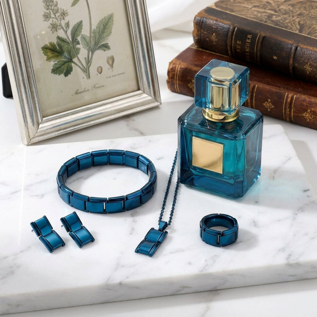 Blue jewelry set including a bracelet, necklace, and ring on a marble surface with a framed picture and books in the background.