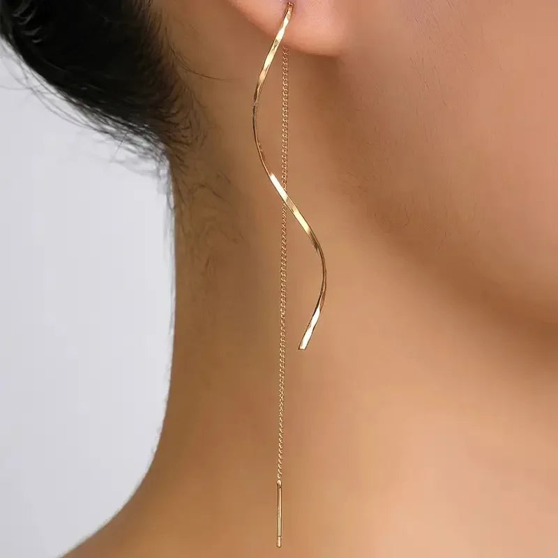 Elegant gold threader earring with twisted design on woman's ear, modern jewelry accessory