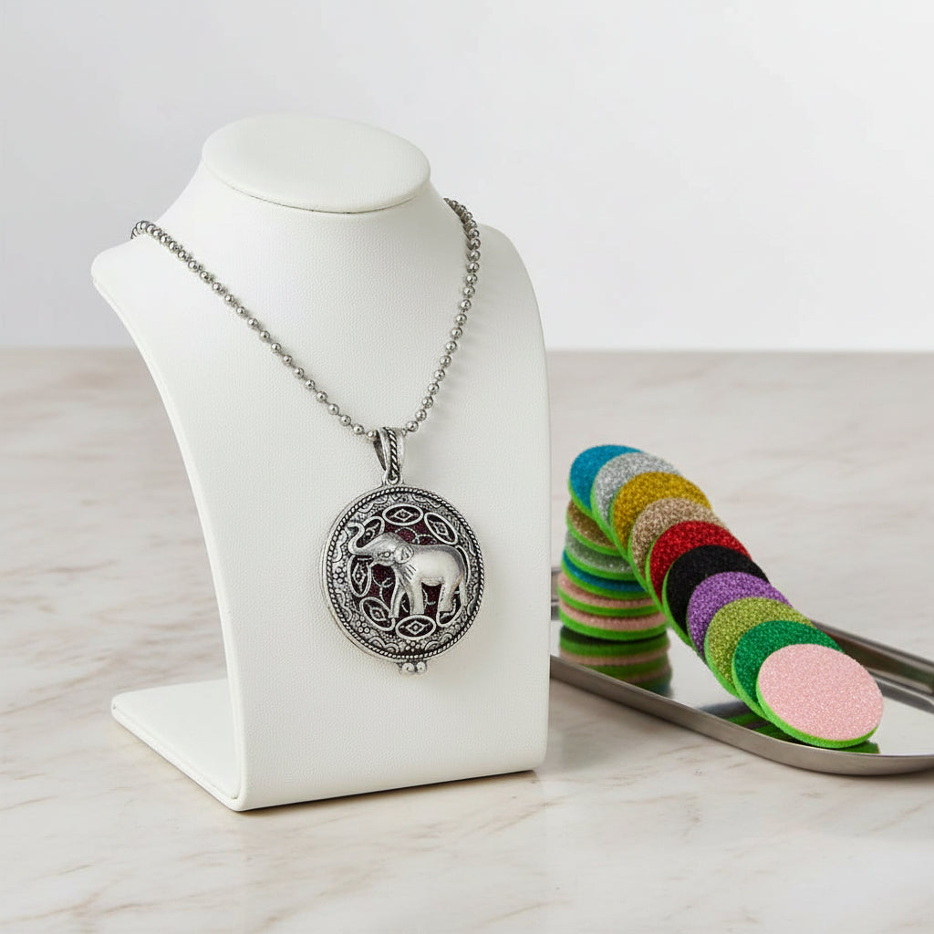 Silver elephant pendant necklace with colorful sample pads on a white background
